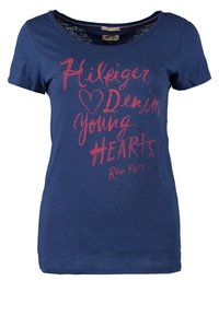 Marinblå bomulls t-shirt med korta ärmar, rundad halsringning och rödtryckt text som säger "Hilfiger Denim young HEARTS Run FREE."