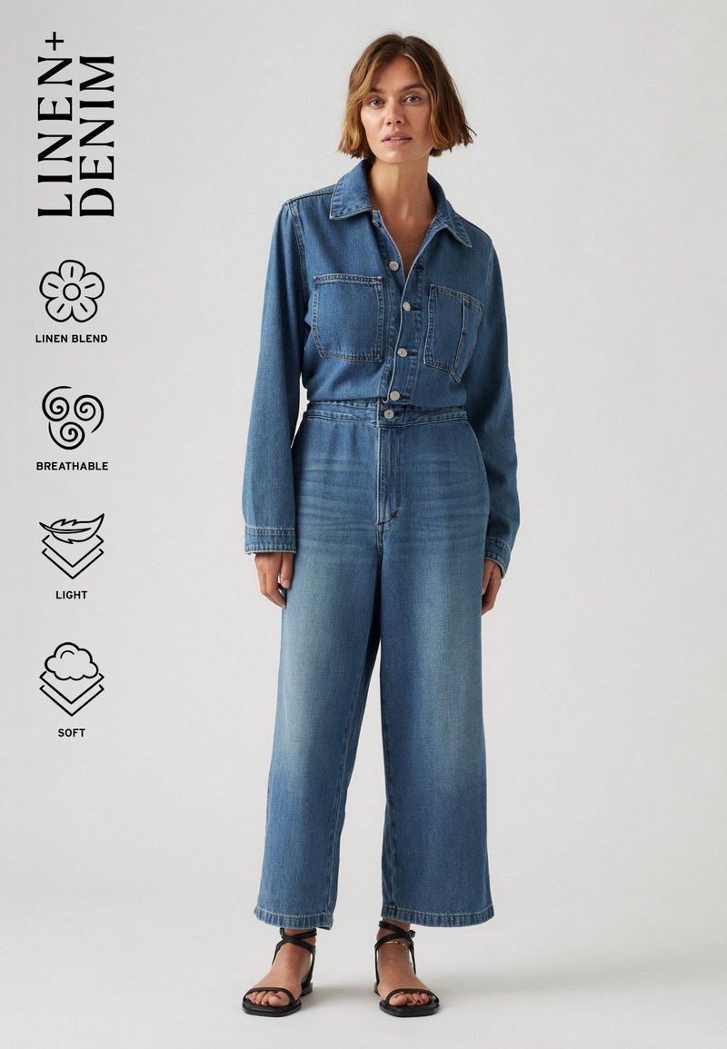 Salopette en denim à manches longues, fermeture à boutons sur le devant, deux poches poitrine, coupe large et délavage bleu clair ; comprend un mélange de lin.