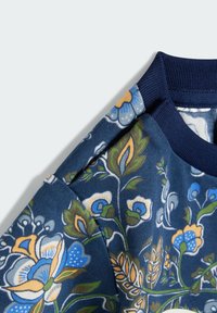Felpa blu navy con motivo floreale, caratterizzata da fiori blu e arancioni, colletto a coste e tessuto testurizzato con una finitura morbida.