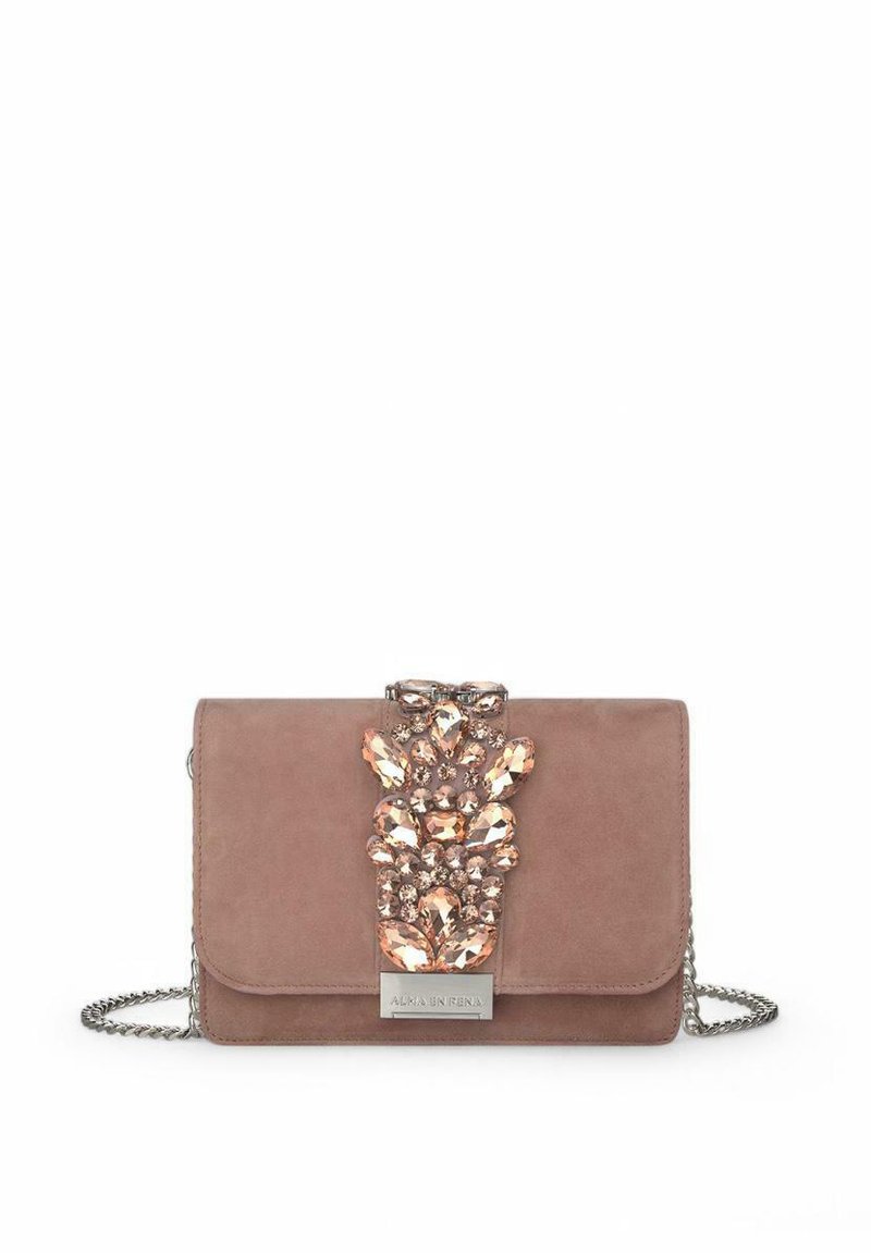 Bolso cruzado de ante rosa con un acento de gema decorativa, herrajes de plata, cierre magnético y strap de cadena. Forma rectangular compacta.