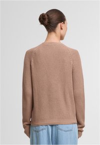 Barna, kötött pulóver hosszú ujjakkal, bordázott textúrával és kerek nyakkivágással. Laza fazont mutat egyenes szegéllyel.