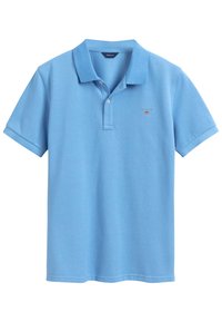 Lyseblå bomulds polo shirt med krave, korte �ærmer og et lille rødt broderet logo på brystet.