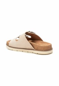 Sandali in suede beige a slip-on con design a intaglio, soletta imbottita e suola in gomma marrone con dettagli di cucitura visibili.