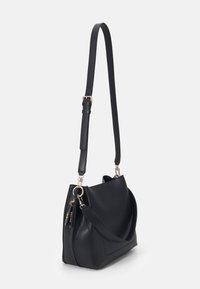 Czarna skórzana torba na ramię z pojedynczym regulowanym paskiem, zaokrąglonym kształtem i złotymi elementami ozdobnymi. Posiada przednią kieszeń na suwak.