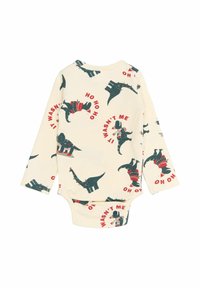 Bodysuit za bebe dugih rukava u kremastoj rebrastoj tkanini s zelenim dinosaurima u blagdanskim džemperima, s crvenim tekstom koji kaže "NISAM TO JA" i "HO HO HO."