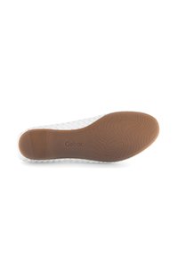 Witte geweven leren schoen met een flexibele bruine rubberen zool. Beschikt over een textuur en subtiele branding op de zool.