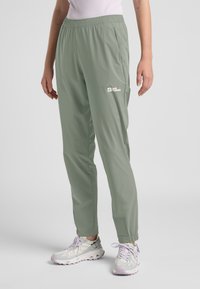 Lichtgroene, lichte broek met een elastische tailleband en zijzakken. Bevat een klein wit logo. Afgemat aan de enkels.