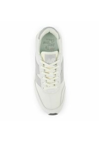 Ljusgrå och off-white sneaker med överdel i mesh och mocka, rund tå, platta snören och grå detaljer. Har New Balance-logotyp på tungan.