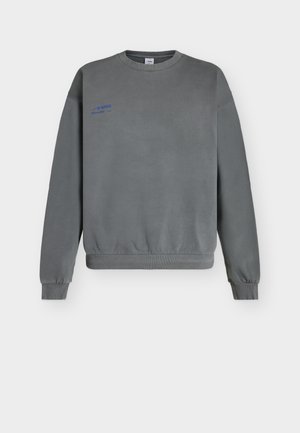 Šedá mikina s kulatým výstřihem a dlouhými rukávy, s žebrovanými manžetami a lemem, a malým modrým logem "ABKK" na levé straně hrudi.