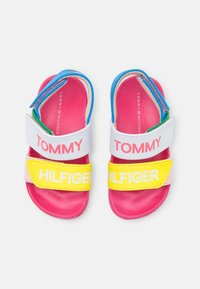 Kleurrijke kindersandalen met een roze en gele design, voorzien van verstelbare banden in wit en blauw, en textuurzolen voor grip.