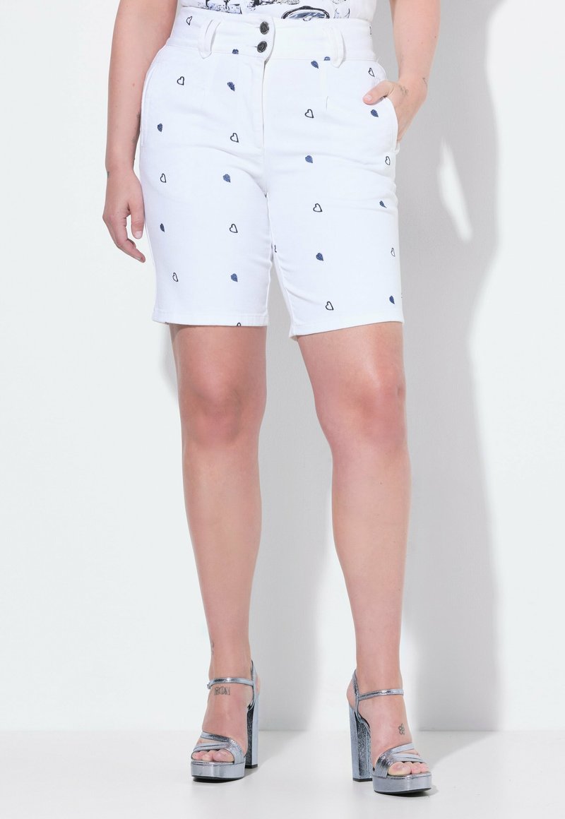 Pantalones cortos de mezclilla blanca con pequeños patrones de corazones en azul marino, cintura alta con dos botones, bolsillos frontales y un diseño ajustado.