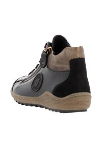 Bottines noires en cuir et en daim avec une semelle en caoutchouc tan. Présente une fermeture éclair sur le côté et un détail de logo embossé sur le côté extérieur.