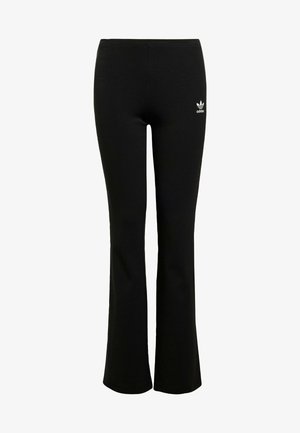 Leggings acampanados negros de canalé con cintura elástica y el logo blanco de Adidas en el lado izquierdo cerca de la cadera. Textura de tela suave.