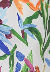 Bloemachtige stof met gedurfde, meerkleurige penseelstrekenpatronen in blauw, groen, roze, oranje en diep rood op een witte achtergrond.
