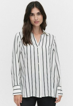 Chemise blanche à boutons avec de fines rayures verticales noires, présentant un col et des manches longues avec des rayures noires accentuées aux poignets.