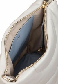 Borsa a mano in pelle beige chiaro con una texture morbida, zip in tonalità oro e un interno multi tasche con rivestimento azzurro chiaro e beige.