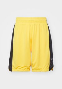 Pantalones cortos deportivos amarillos con paneles laterales negros, hechos de material de malla transpirable. Cuentan con una cintura elástica y un detalle de logo en el lateral.