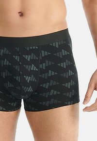 Czarne bokserki z geometrycznym wzorem trójkątów w ciemnoszarym kolorze. Posiadają jednolity czarny pas w talii i gładką teksturę.
