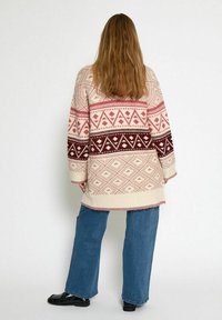 Gebreide cardigan met geometrische patronen in roze, bordeauxrood en crème, met een ontspannen pasvorm, verlaagde schouders en lange mouwen.