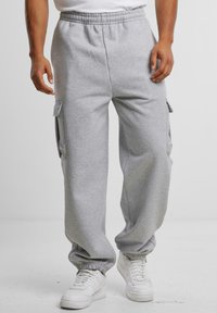 Grå sweatpants i mjukt material, med en avslappnad passform, elastisk dragsko i midjan och cargofickor på sidorna.