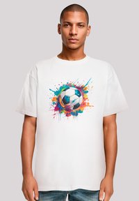 White cotton t-shirt featuring a colorful splash design around a black and white soccer ball. Short sleeves and relaxed fit.
