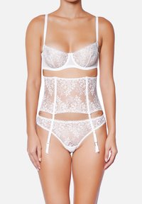 Ensemble de lingerie blanche avec un design en dentelle florale, soutien-gorge à armatures, porte-jarretelles taille haute et culotte assortie avec bretelles réglables.
