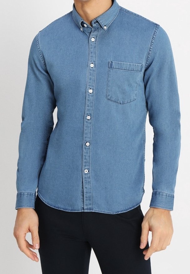 Koszula dżinsowa zapinana na guziki w jasnoniebieskim kolorze, z wysublimowanym kołnierzykiem, pojedynczą kieszenią na piersi i zwężanym dołem. Gładka tekstura z białymi guzikami.