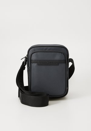 Črn pravokoten torbica čez ramo, izdelana iz trpežnega materiala. Ima sprednji žep z zadrgo, nastavljiv trak in logo na sprednji plošči.