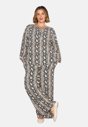 Schwarzes und beiges Schlangenprint-Zweiteiler-Outfit, bestehend aus einer lockeren Tunika mit weitem Oberteil und Knopfleiste sowie einer entspannten Hose mit Taschen.