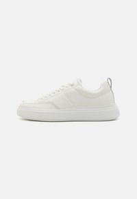 Białe sneakersy z gładkiej skóry, okrągłym czubku, sznurówką z przodu oraz kontrastującym szarym uchwytem z tyłu. Gruba, biała, gumowa podeszwa.