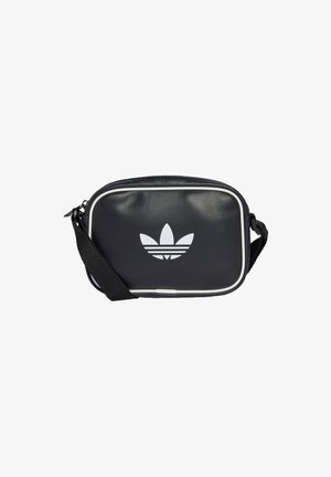 Czarna prostokątna torba na ramię z białym obszyciem, logo Adidas trefoil na przodzie pośrodku oraz regulowany czarny pasek na białym tle.