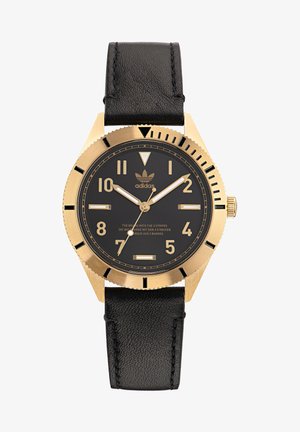 Auksinės spalvos laikrodis su juodu ciferblatu, dideliais šviesą atspindinčiais valandų žymekliais, juodu odiniu dirželiu ir įpjautu rėmu. Su Adidas logotipu.