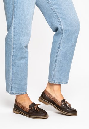 Braune Leder-Bootsschuhe mit braunem Akzent, Schnürdetail und Gummisohle, kombiniert mit hellblauen Denim-Jeans.