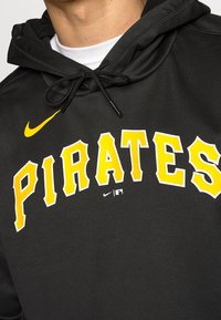 Felpa nera con cappuccio realizzata in tessuto morbido, con la parola "PIRATES" in bold giallo. Include un logo Nike e un cappuccio con cordini.
