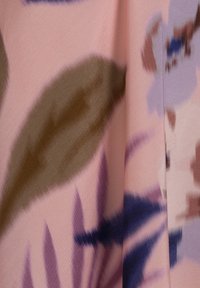 Květinový látkový vzorek s růžovým pozadím a velkými abstraktními listy v hnědé a fialové barvě, hladká textura a jemný lesk.