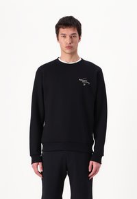 Black sweatshirt in soft fabric, featuring a crew neckline, ribbed cuffs and hem, with a small embroidered logo on the chest.