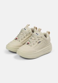 Sneaker sportive beige con tomaia in materiale sintetico liscio, lacci testurizzati, collarino imbottito e dettagli con logo. Punta arrotondata e soletta ammortizzata.