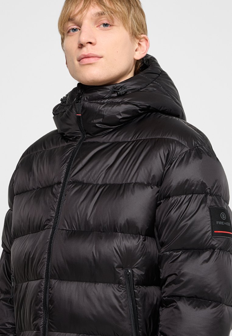 Schwarze Steppjacke mit hohem Kragen und verstellbarem Kapuze. Mit horizontaler Steppung, Reißverschlusstaschen und einem Markenpatch am Ärmel.