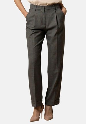 Pantaloni in lana a quadri grigi con pieghe, vita alta, gambe affusolate, orli arrotolati e tasche frontali, abbinati a tacchi di colore chiaro.