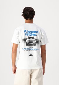 HUF LEGEND RETURNS TEE UNISEX - Trükipildiga T-särk - white