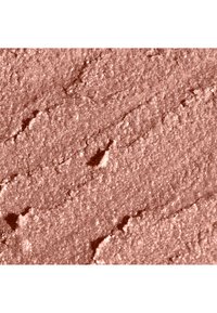 Pressed pudderrouge i en varm ferskentone med en fin, fløyelsaktig tekstur og subtil glans, som viser et jevnt, ujevnt overflatemønster.