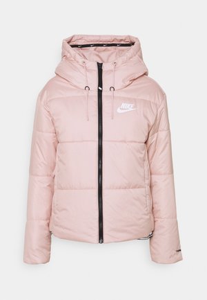 Doudoune Nike rose clair avec capuche, fermeture éclair noire à l'avant, cordons et logo Nike blanc sur la poitrine.