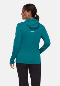 Felpa con cappuccio color verde petrolio con design aderente, materiale leggero e cappuccio. Presenta il logo del marchio sul retro e fori per il pollice sulle maniche.