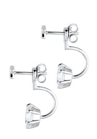 Boucles d'oreilles en argent avec pierre transparente taillée, présentant un design arrondi et un système de fermeture arrière sécurisé. La finition polie met en valeur la clarté.