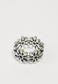 Bague en argent avec un design creux, des pétales arrondis, des formes de fleurs alternées et des bords lisses, créant une apparence légère.