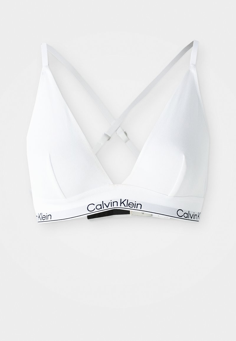 Hvid trekantet bralette med tynde, justerbare krydsede rygstropper, med et mærket elastikbånd med 'Calvin Klein' i sort. Glat tekstur.