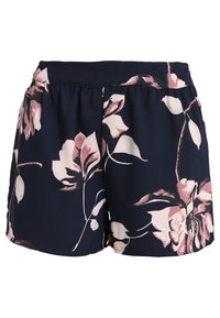 Navy blue shorts with pink and white large floral print and elastic waistband, made from lightweight fabric.
