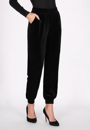 Zwarte fluwelen joggingbroeken met een elastische tailleband, zijzakken en opgerolde enkels. Soepele textuur, slim-fit en een veelzijdig ontwerp.