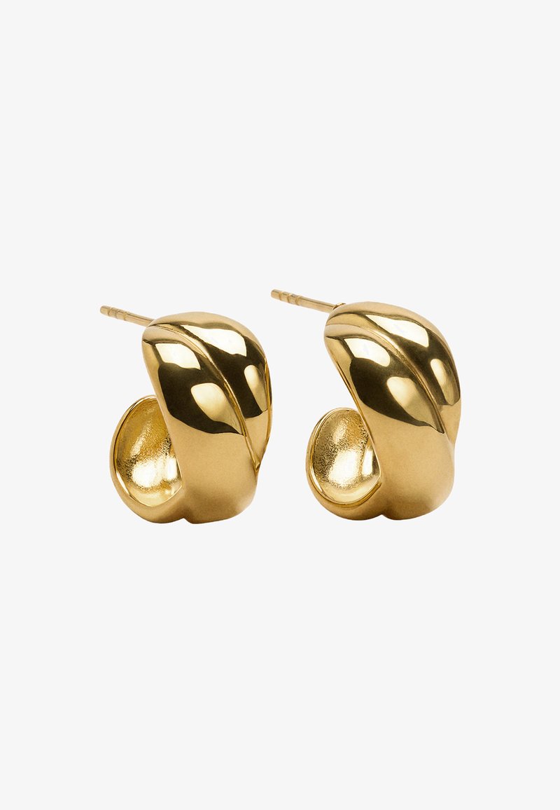 Złote kolczyki o gładkim, zakrzywionym kształcie. Charakteryzują się refleksyjną powierzchnią i teksturowanym wykończeniem wewnętrznym. Proste zapięcie na sztyft.
