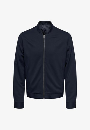 Giacca bomber navy con zip frontale, polsini e orlo a costine, realizzata in tessuto morbido, con colletto rotondo e tasche laterali.